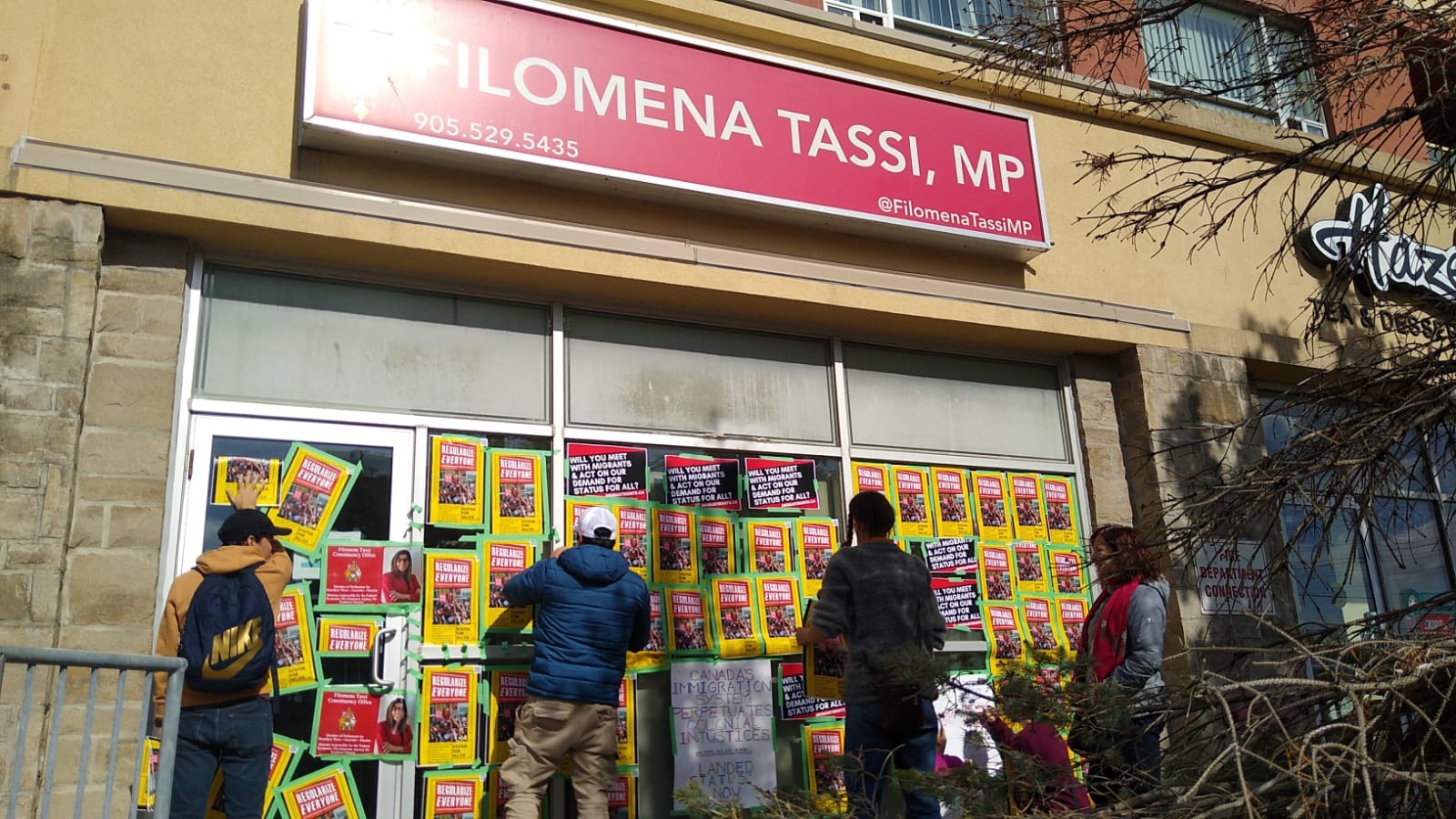 A photo of posters in support of status for all on Filomena Tassi's office