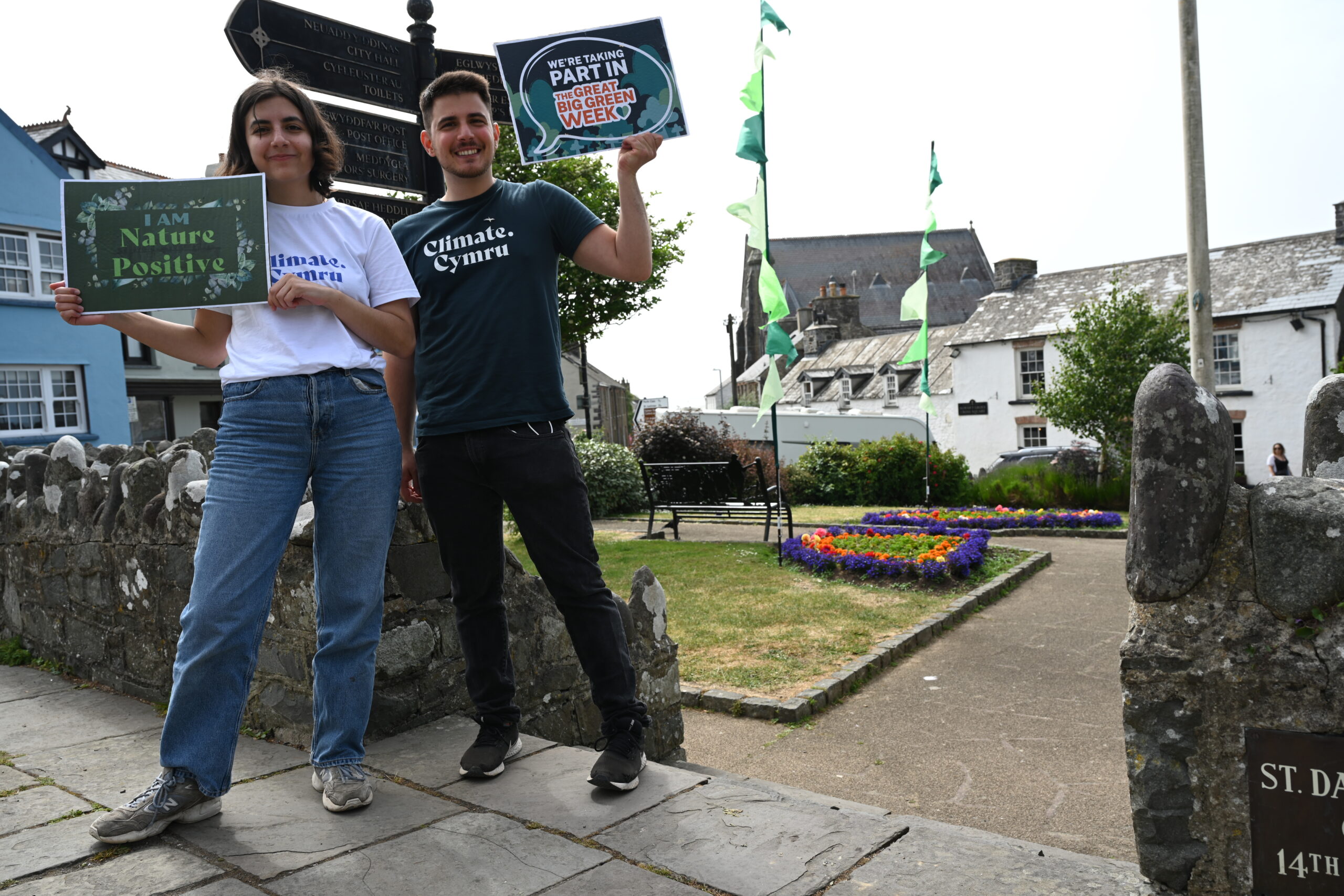 Male and female holding Great Big Green Week sign in St Davids