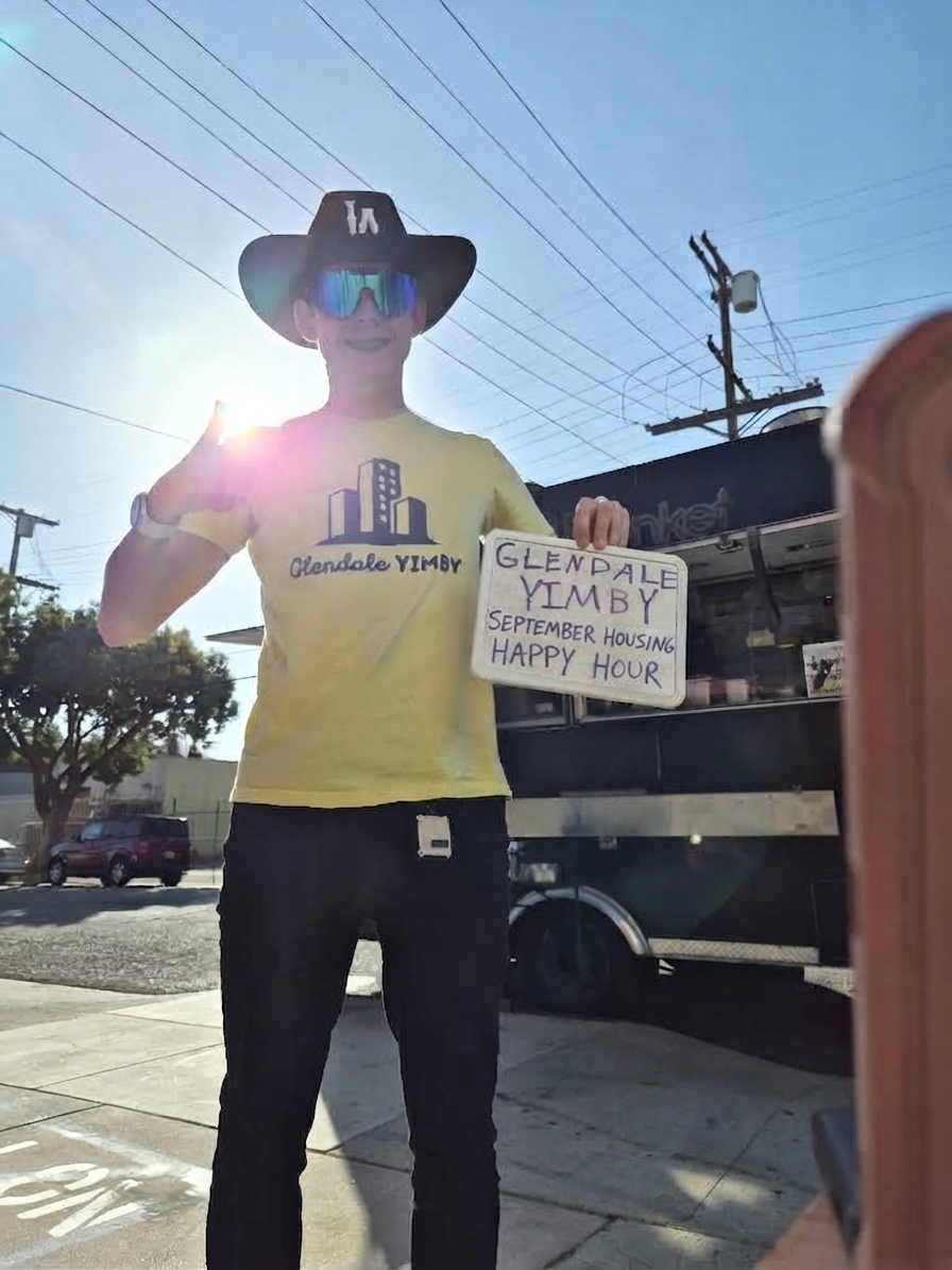 Shane holding up sign for YIMBY meeting