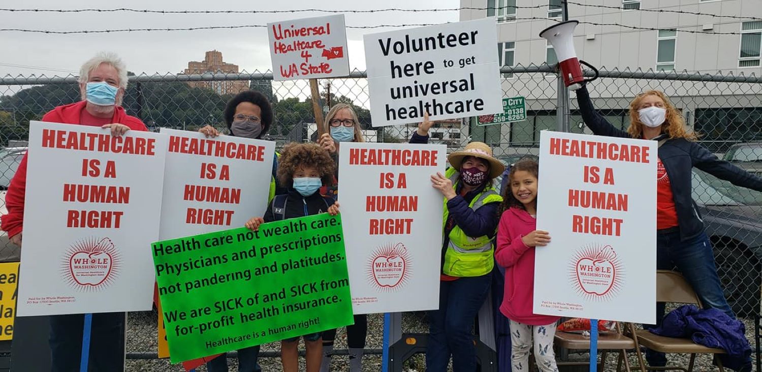 group of volunteers holding Healthcare is a Human Right signs