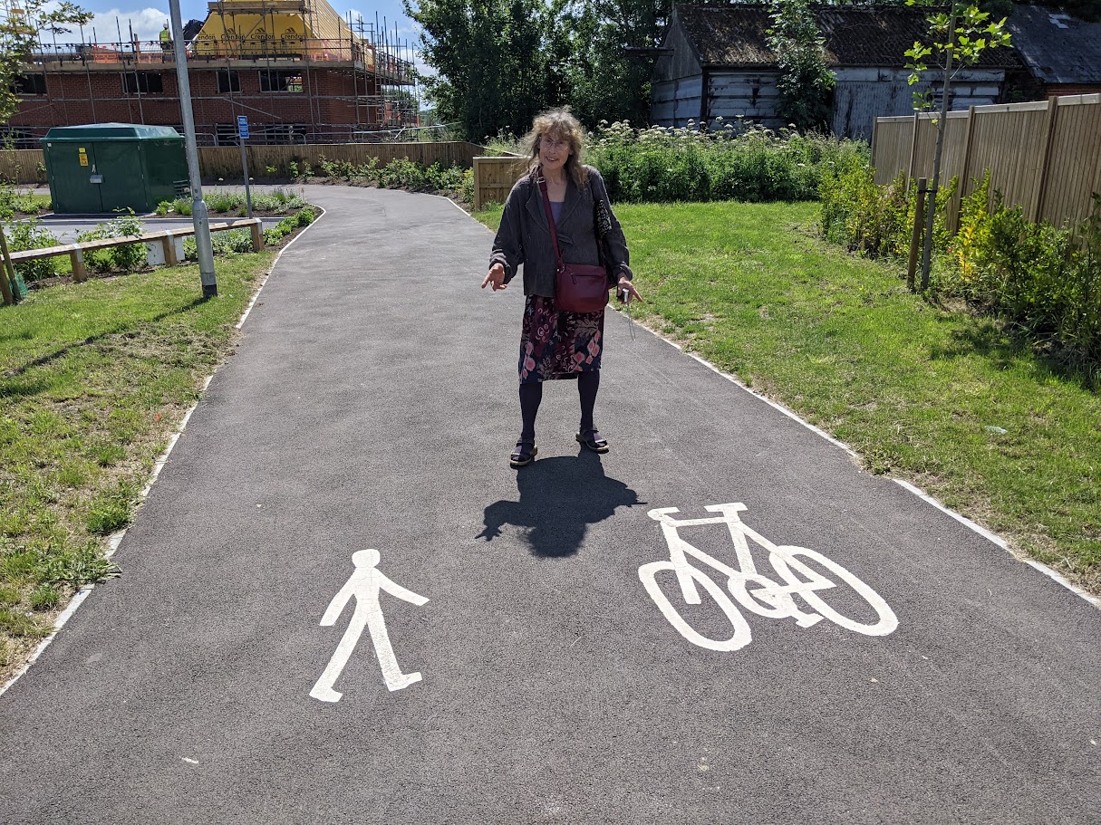 Woman points at cycling and walking symbols