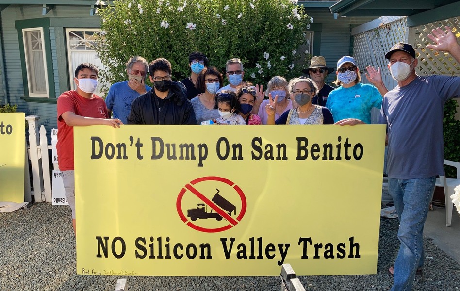 Volunteers display a sign they painted.