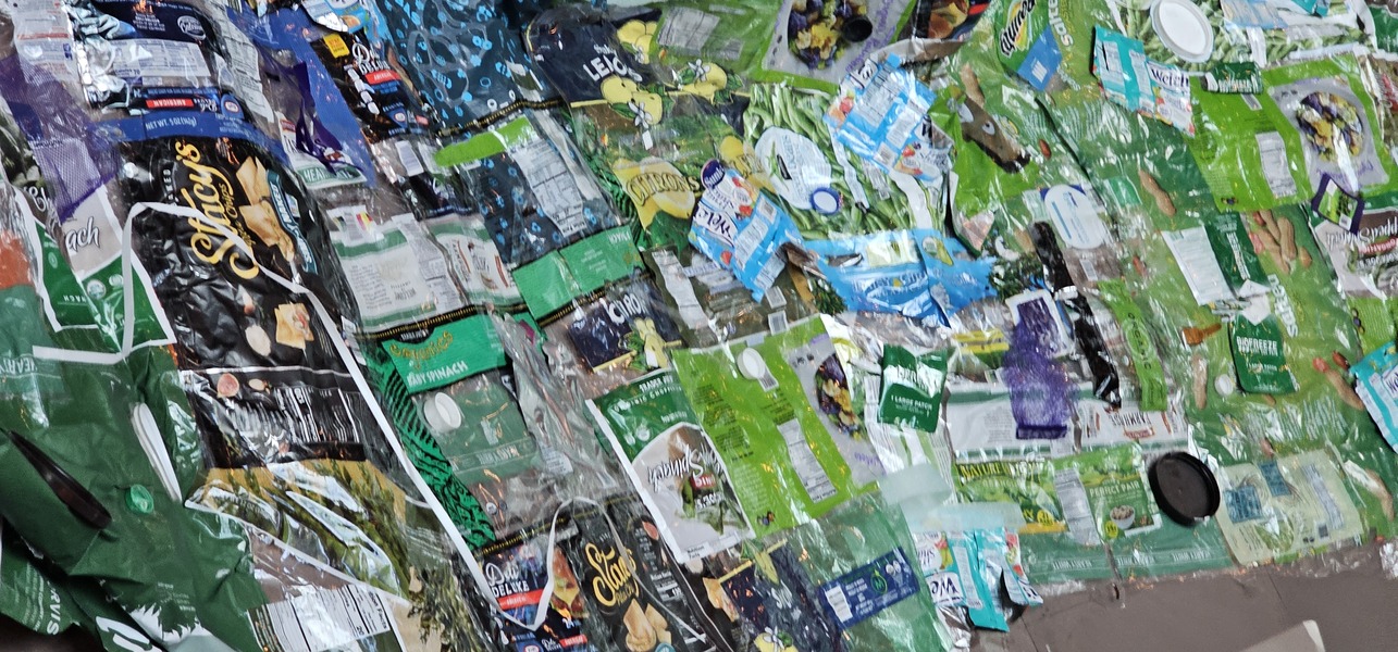An enormous array of separate single use plastic packaging, stitched together.