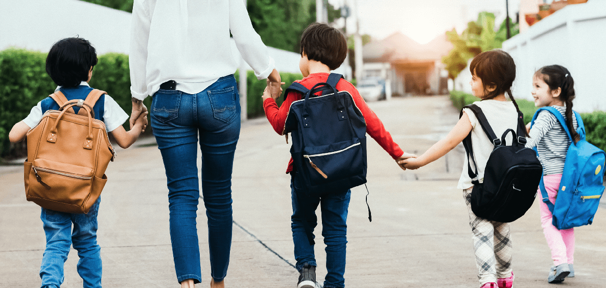 Children walking to school with an adult.