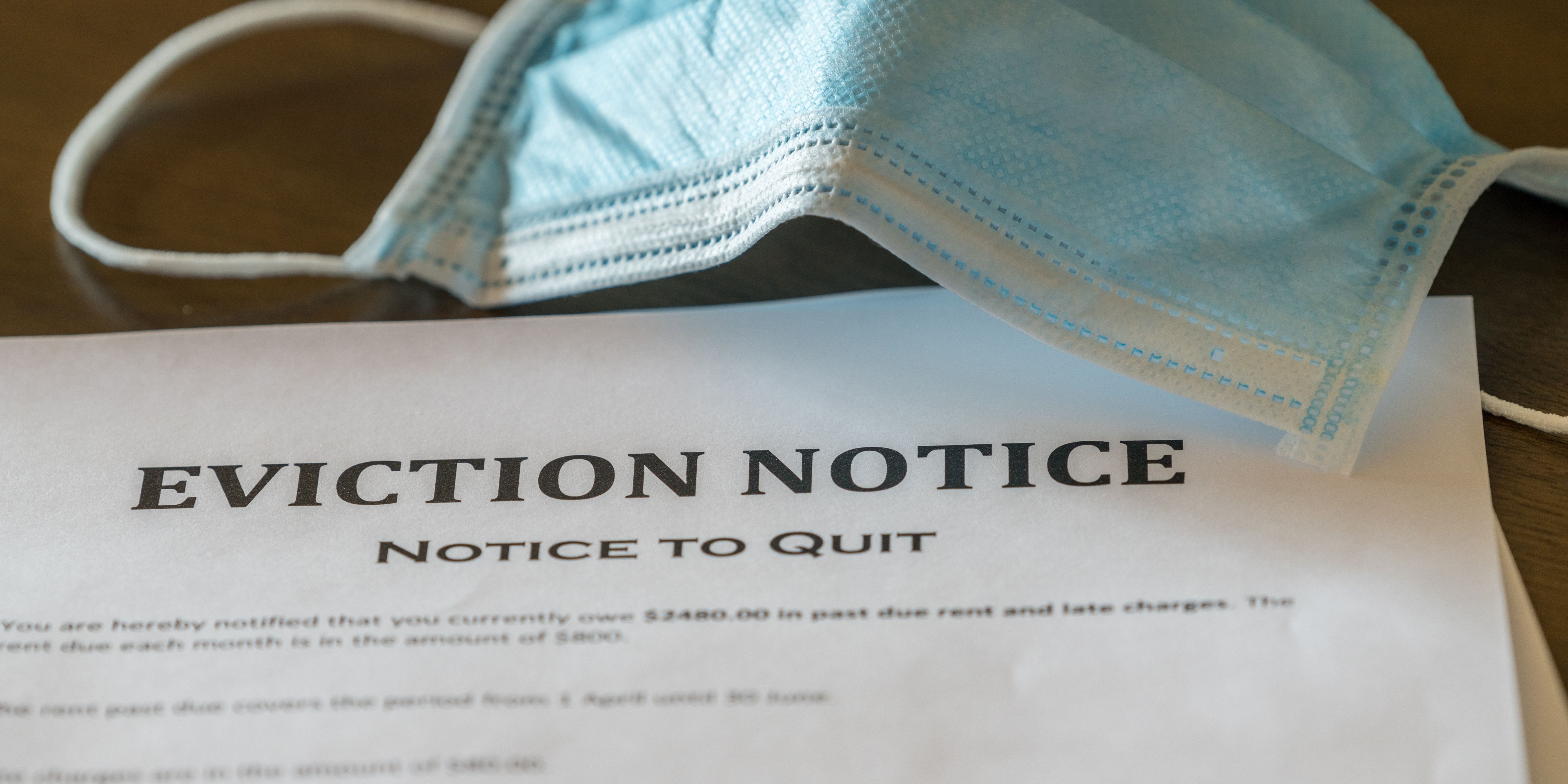A mask sitting next to eviction notice paperwork.