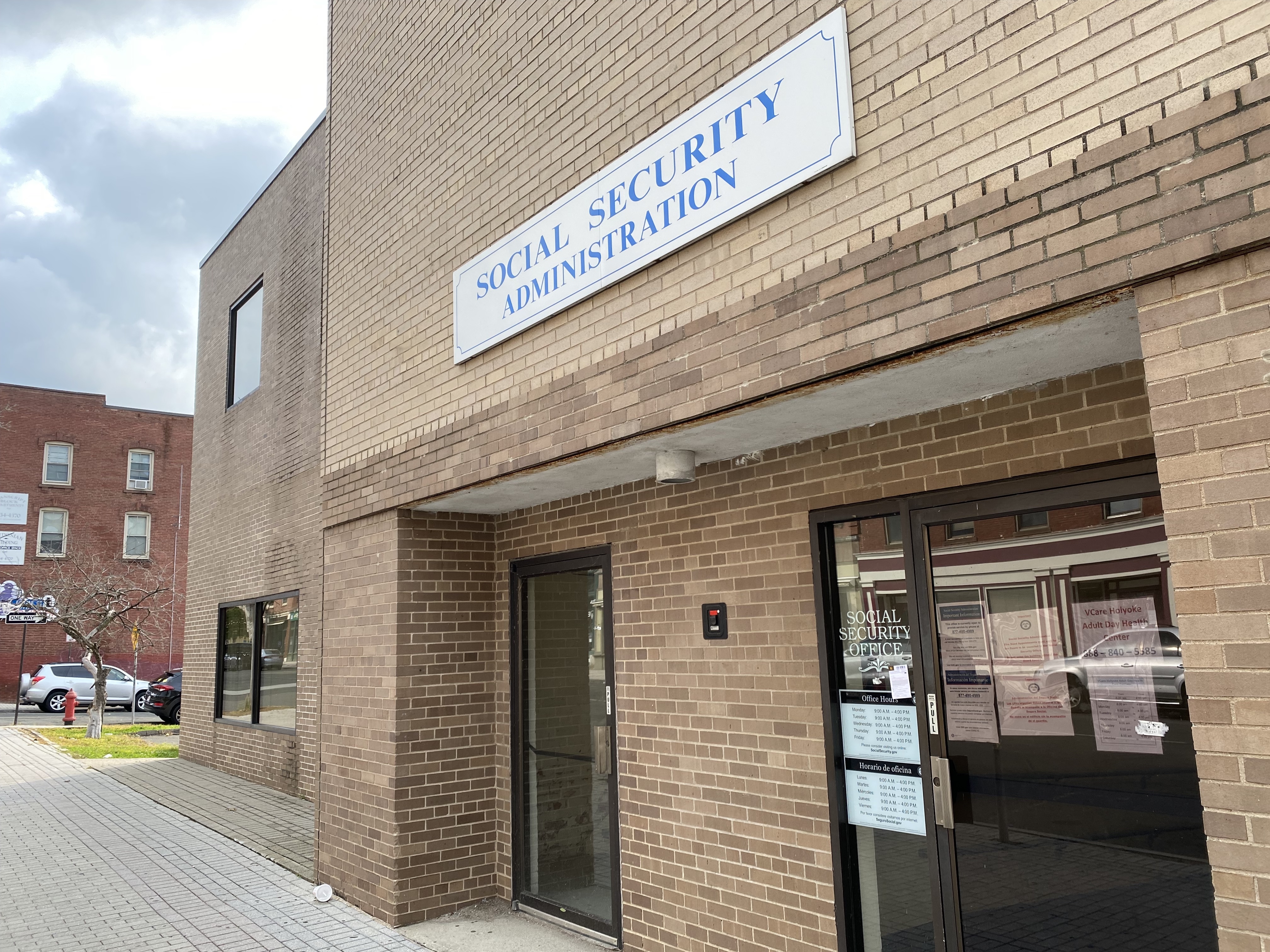 A brown brick building in the middle of a city block reads "Social Security Office"