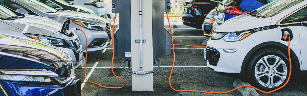 Electric vehicles charge in the parking lot of an apartment complex