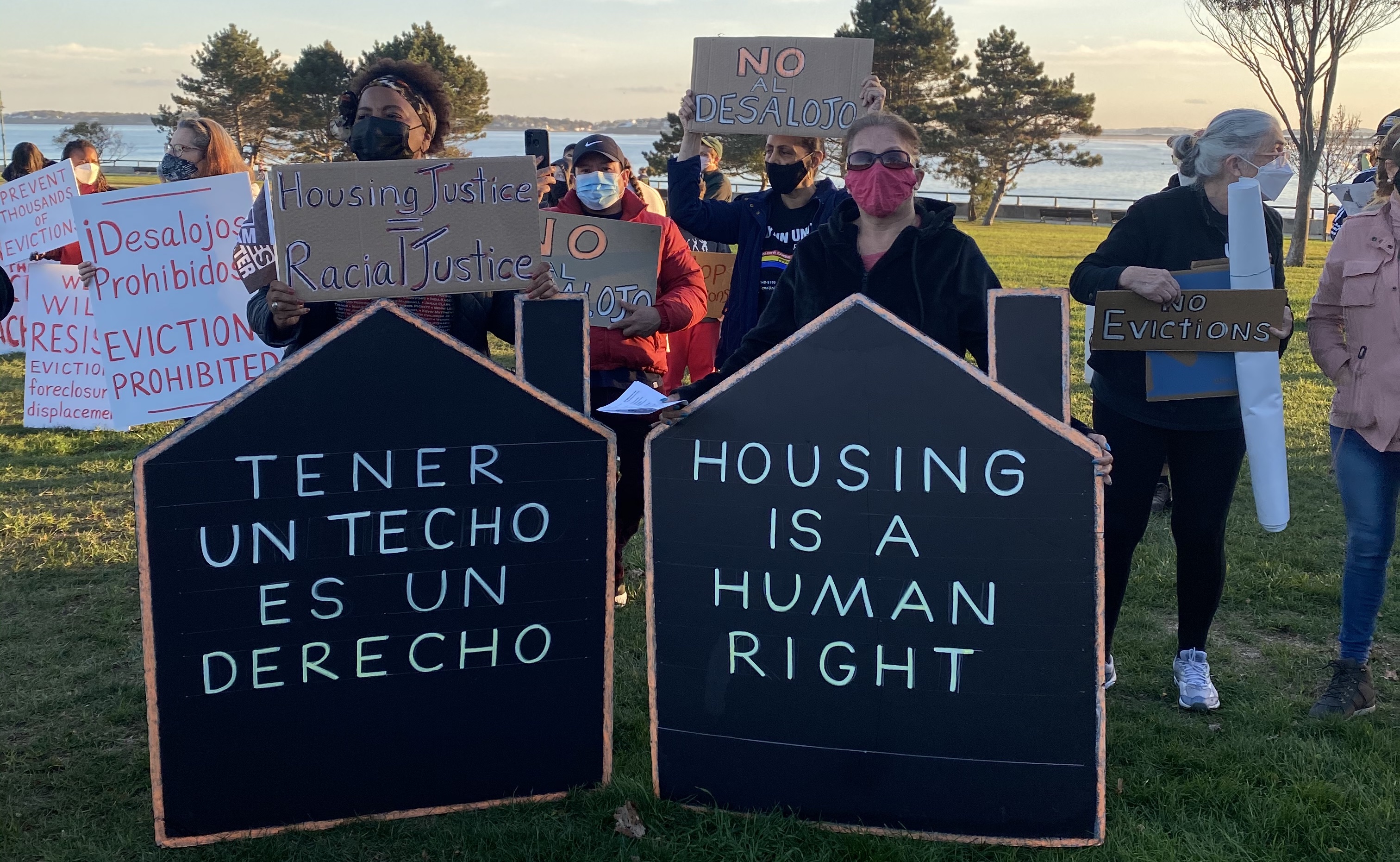 photo of people holding housing justice signs including housing is a human right and tener un techo es un derecho