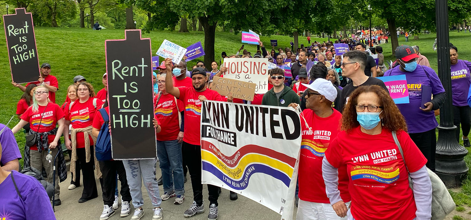 Photo of large crowd marching through Boston Common to demand rent control. Signs include "Rent is too high" "contro de renta ahora." Marchers at front are carrying a Lynn United for Change banner.