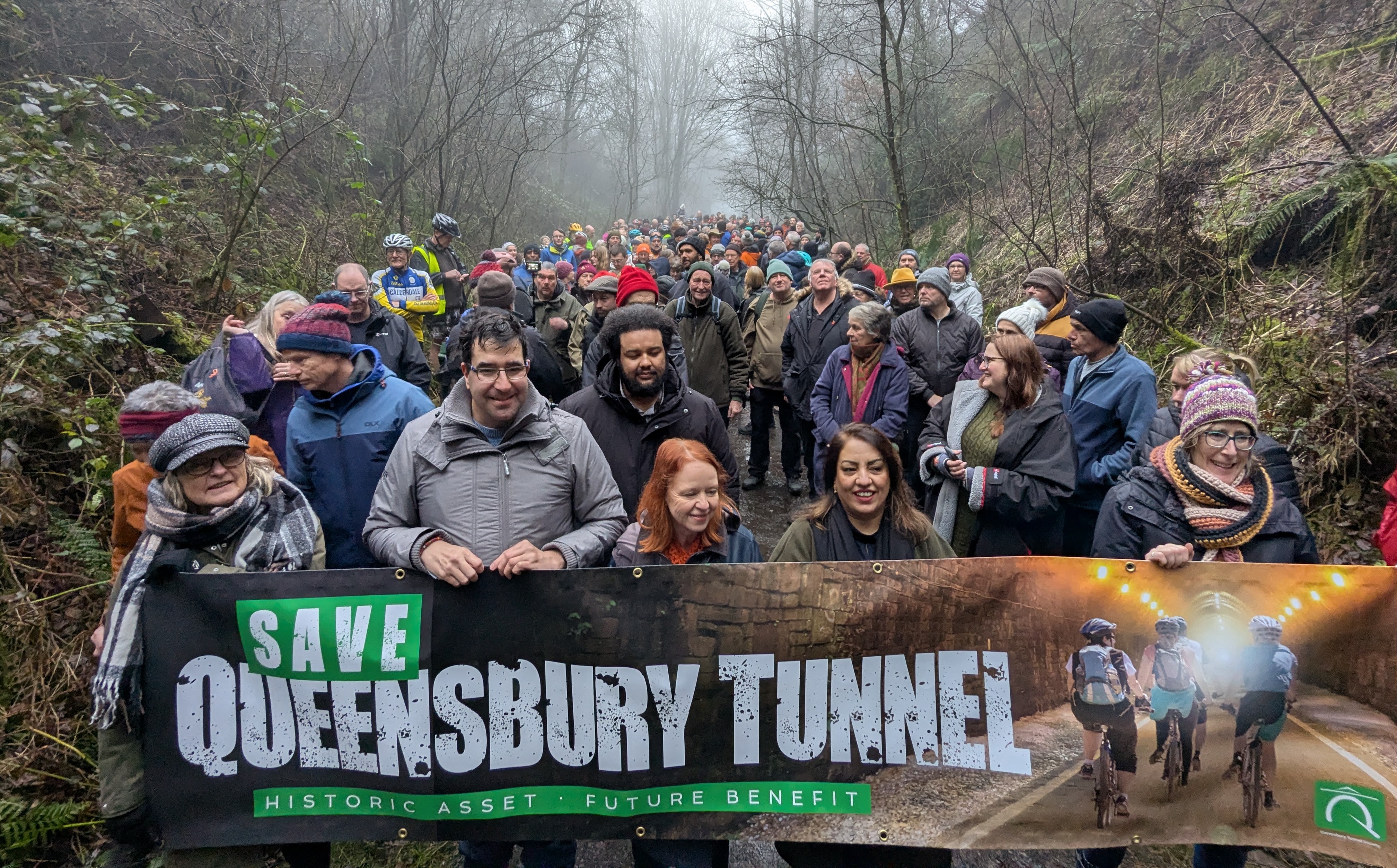Over 200 people gathered in the cutting facing the northern portal of the Queensbury Tunnel, with those at the front holding a banner saying 'Save Queensbury Tunnel: Historic asset, future benefit''