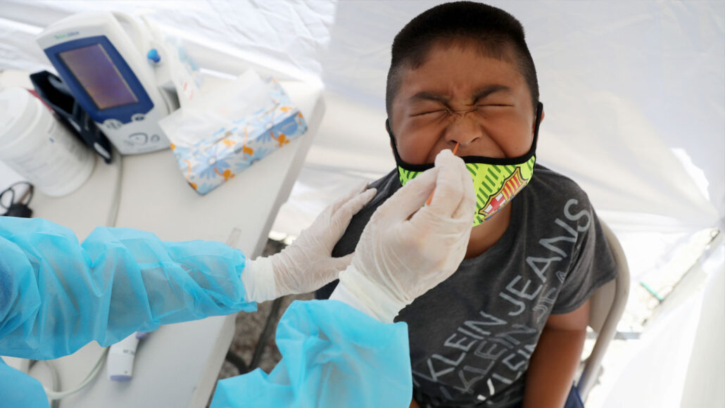 a young child grimaces getting his covid test