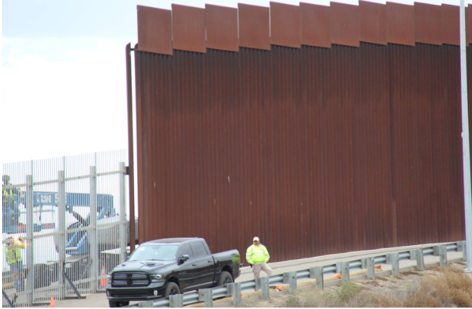 Thirty foot trump wall butting up against 18 foot existing barrier at the beginning of Friendship Park.  And Group of people on US side looking through both walls trying to greet people on the Mexican side