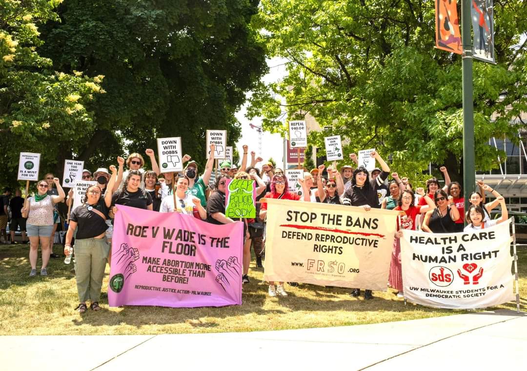 Photo of people marching in support of abortion access, carrying banners and signs, in Milwaukee