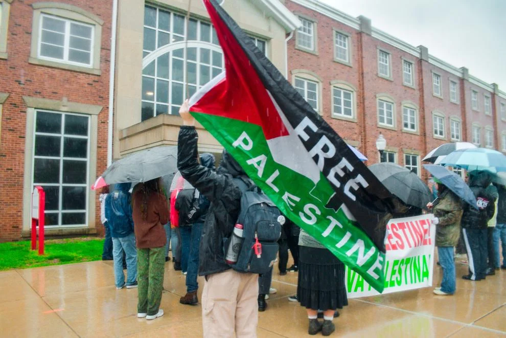 Group of students in front of Schroeder Hall with a flag that says "Free Palestine"