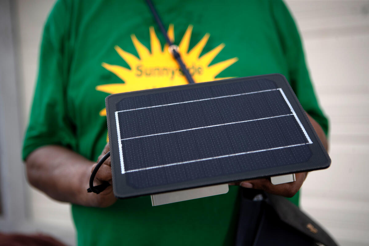 A resident volunteering with a community-based environmental justice organization in Houston's historically Black Sunnyside holds an air monitor.
