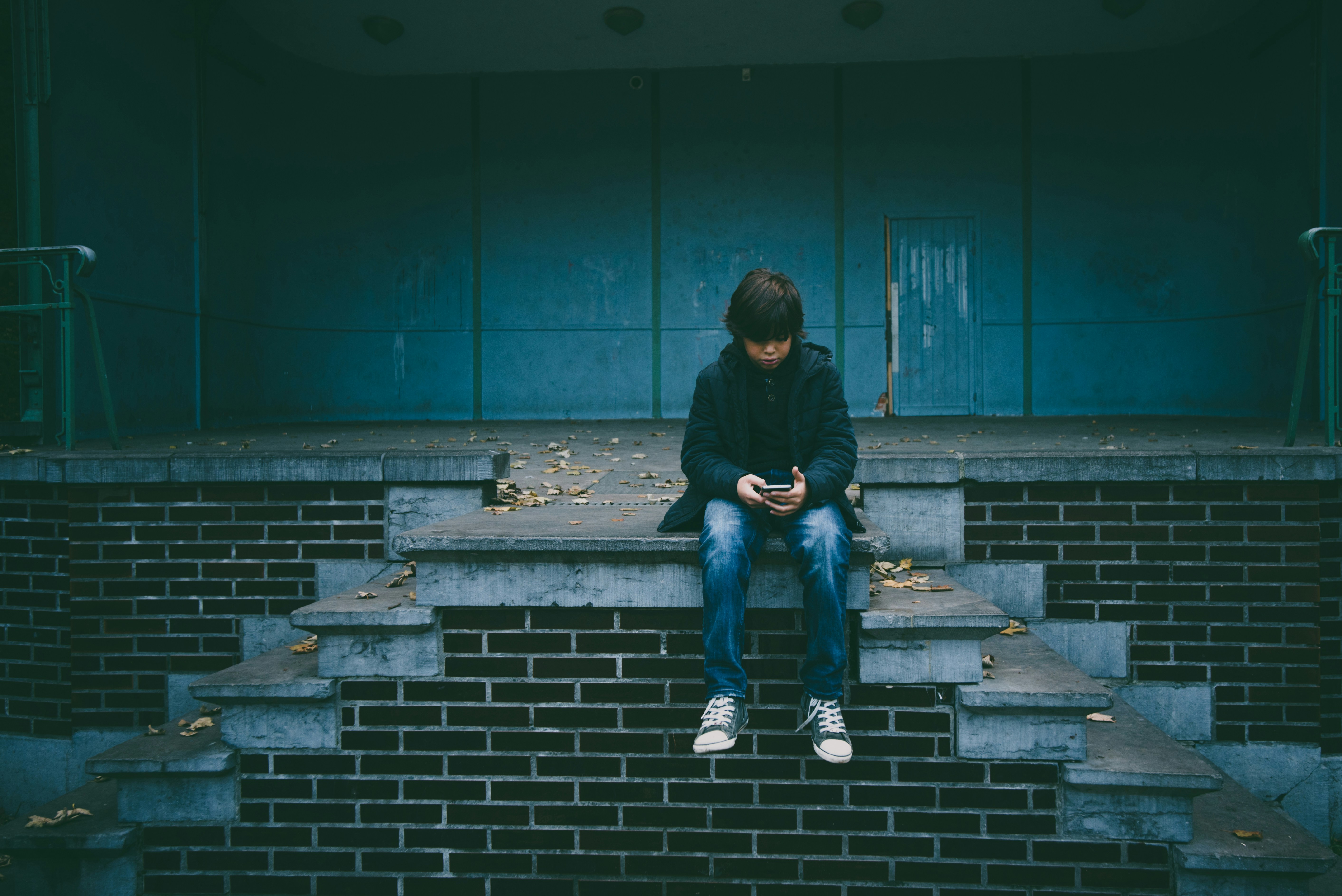 A young boy looks at his phone