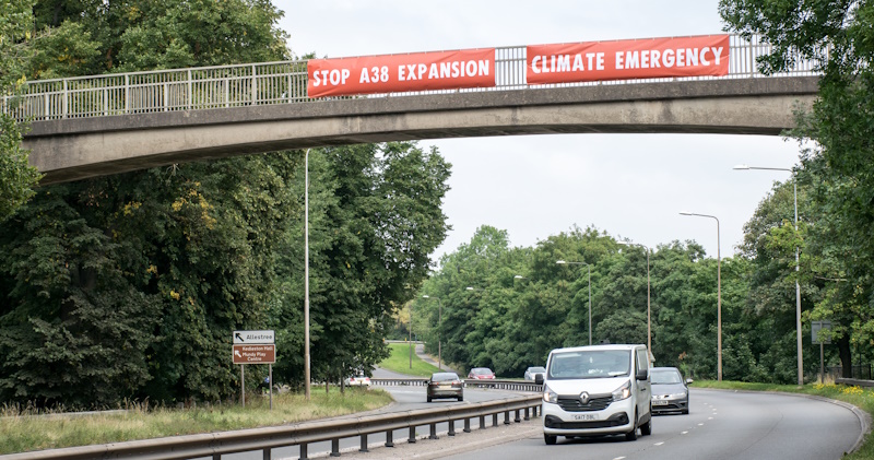 Stop A38 Expansion and Climate Emergency banners on bridge over empty A38.