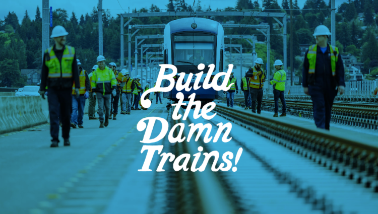 An image of construction workers walking along a light rail track next to a train, with Build the Damn Trains text overlayed on top