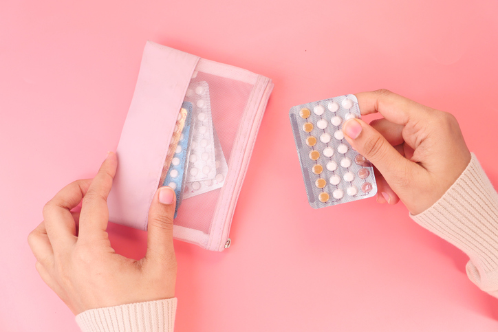 Women hand golding birth control pills close up stock photo