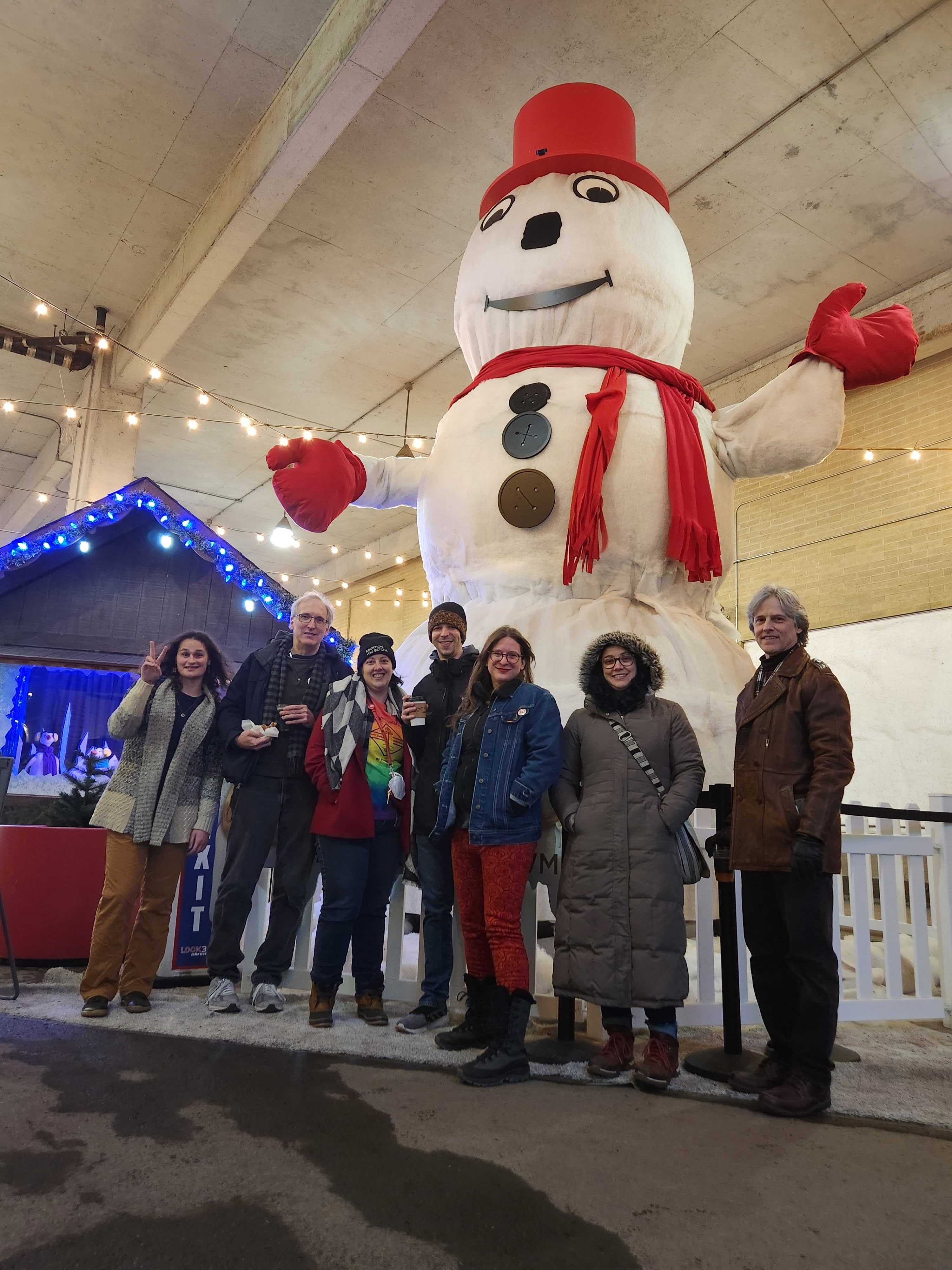 Akron DSA group shot in front of Archie, Akron's 18ft talking snowman