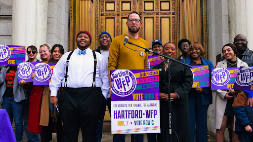 Photo of Josh Michtom, Tiana Hercules, Alex Thomas, and supporters holding Hartford WFP signs