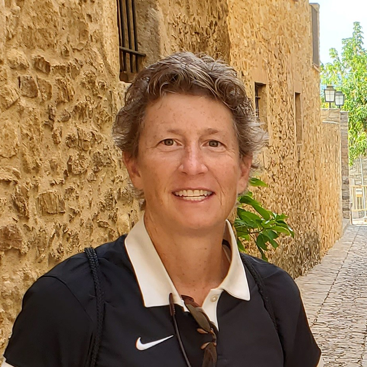 WFP volunteer Laura Kramer poses outside wearing a black Nike shirt with a white collar