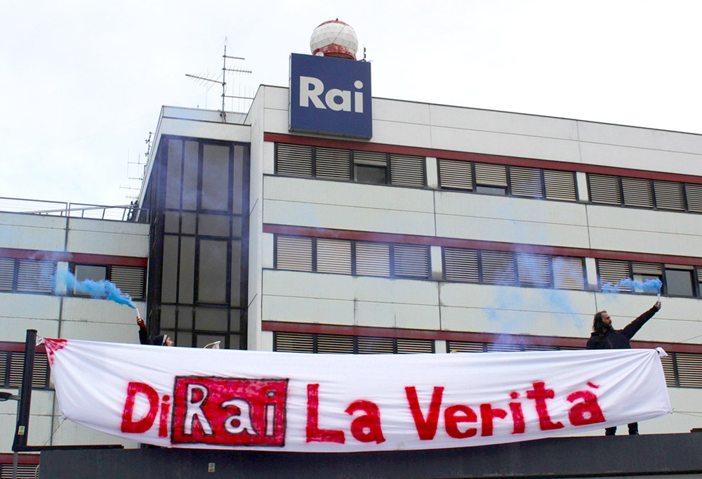 Rebels hold blue smoke flares and a banner outside a RAI HQ
