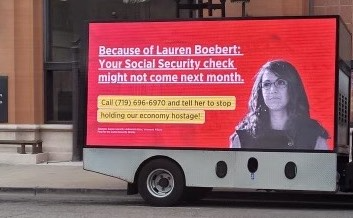 Billboard truck parked in front of senior's center in Pueblo, Colorado, wtih text 'Because of Lauren Boebert Your Social Security check might not come next month. Call and tell her to stop holding our economy hostage!'