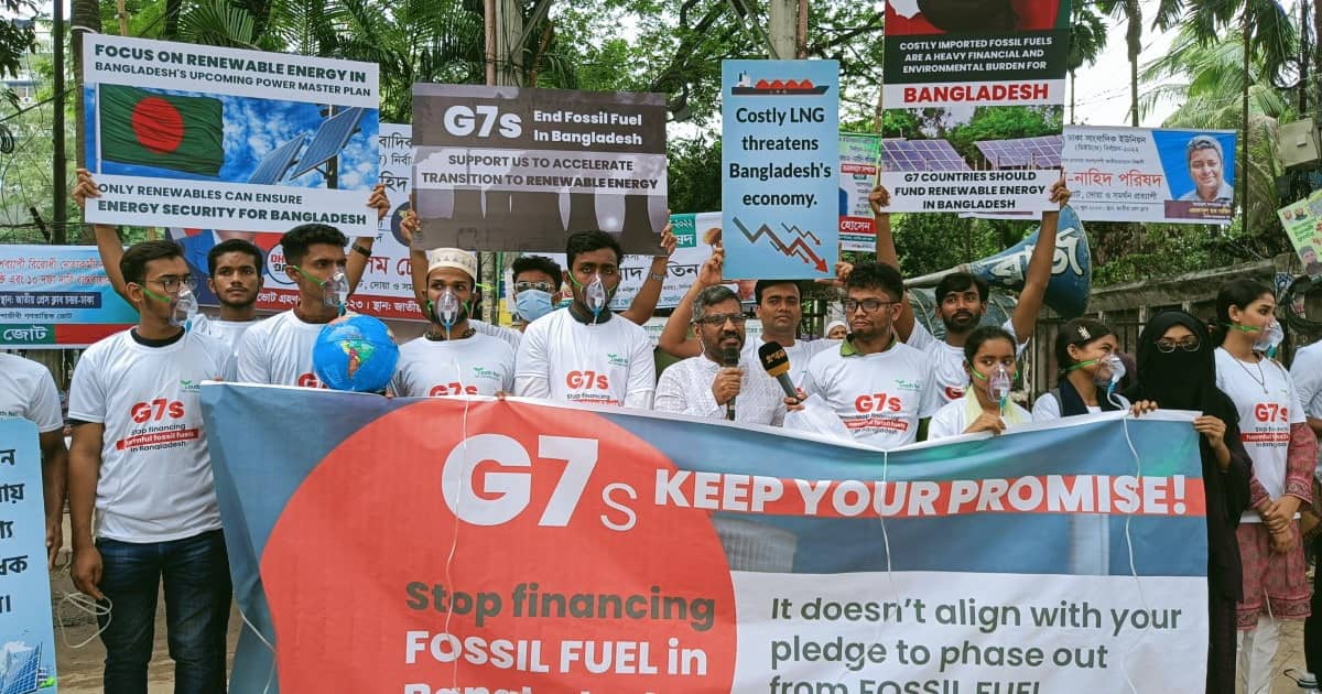 Activists hold a G7 Keep Your Promises banner while wearing oxygen masks