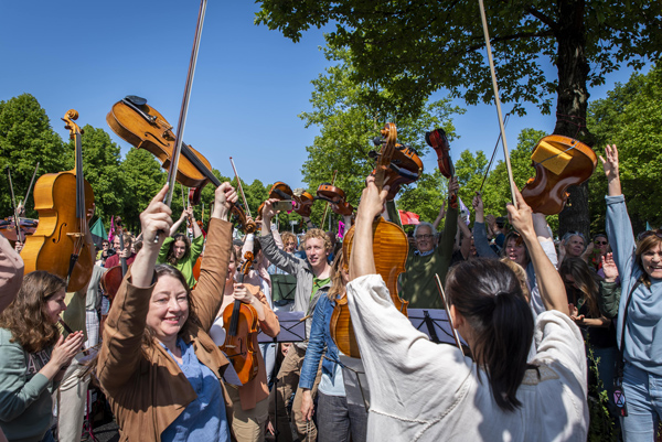 Members of the orchestra hold up their instruments in celebration