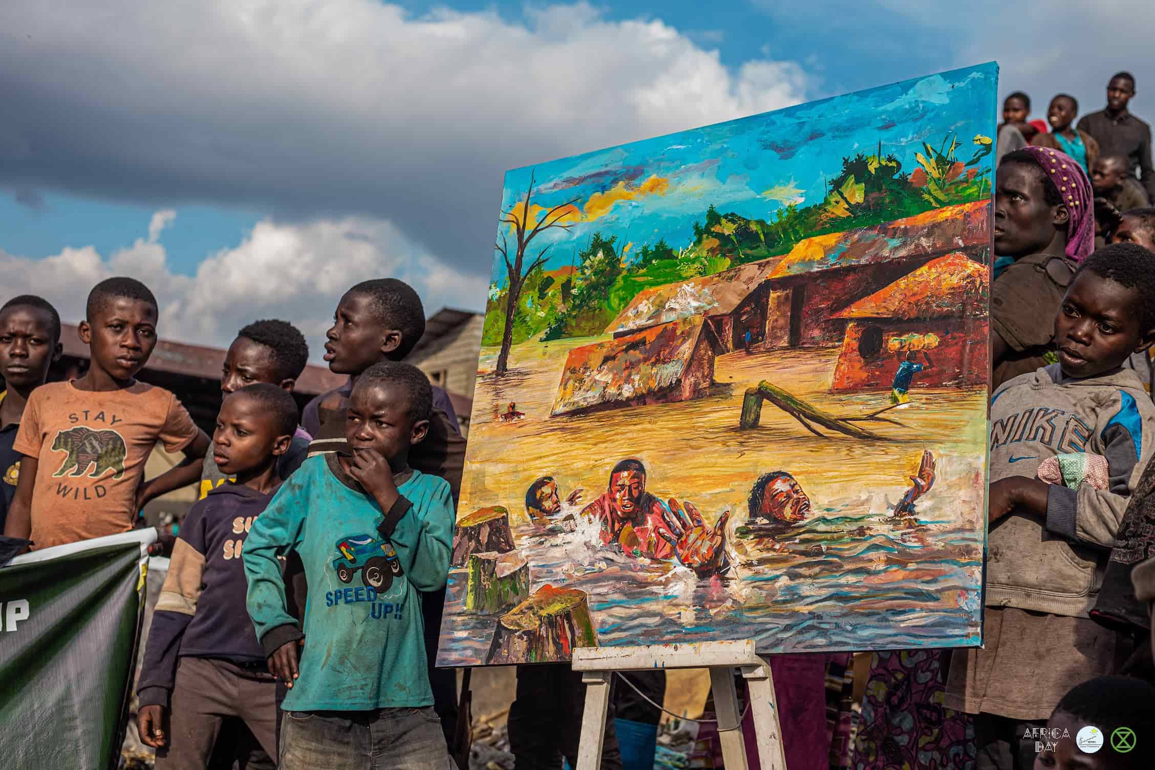 Children stand around a painting showing an apocalyptic scene of a village on fire and people drowning