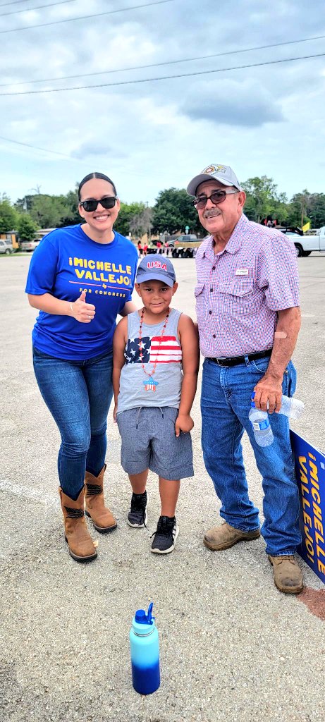 Michelle stand with supporters and gives a thumbs up. 