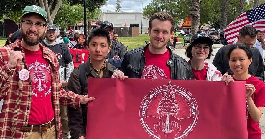 Members of Stanford Graduate Workers Union with banner
