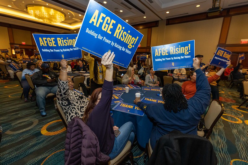 AFGE members hold AFGE Rising signs