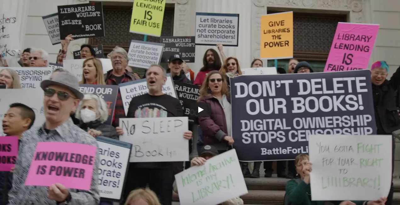 Still frame of protesters holding signs in the video