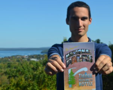 An activist holding a postcard reading "National Parks: Think Outside the Bottle"