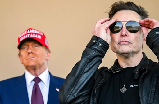 Photo of Elon Musk standing in front of Trump