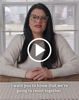 Rashida sits at a table in front of a window, staring directly into the camera. the subtitle reads 'I want you to know that we're going to resist together.'