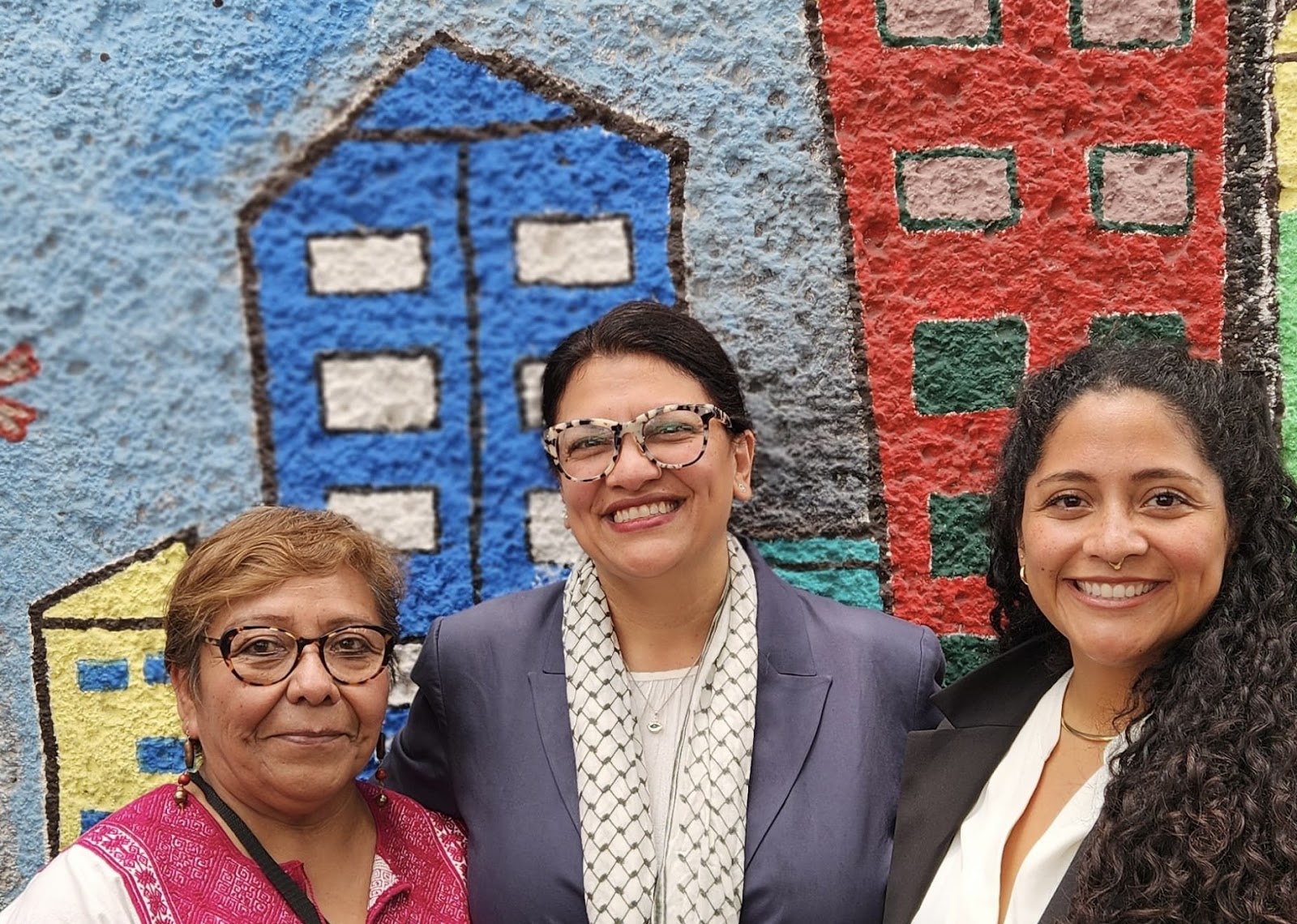 Rashida smiles next to two Casa staff members
