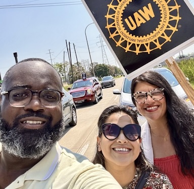 Photo of Denzel, Gaby, and Rashida on the picket line with UAW