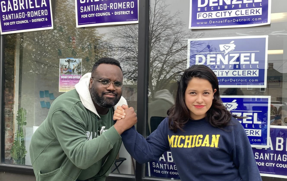 Photo of Denz and Gaby in younger days, doing an epic handshake. Gaby is wearing a University of Michigan sweatshirt.
