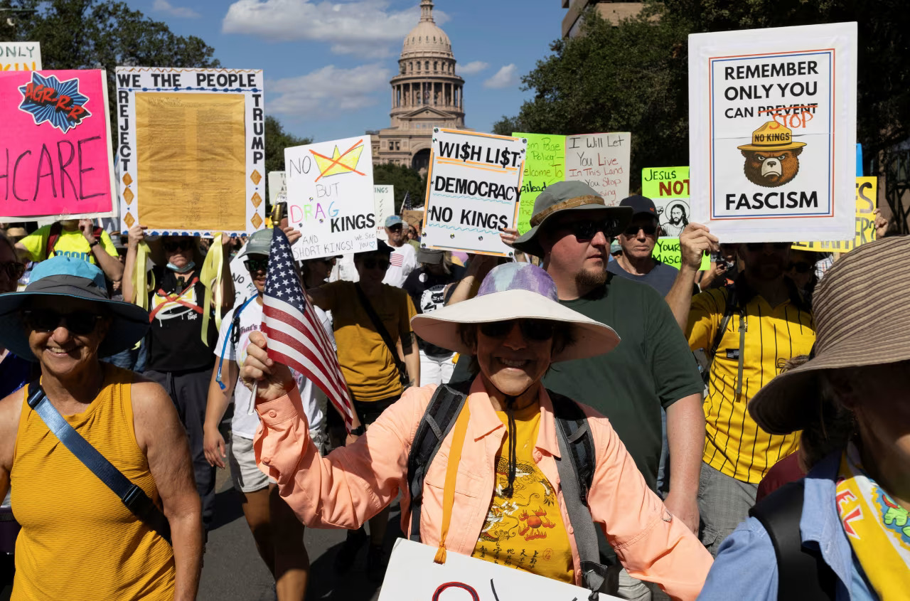 Photo of No Kings Day rally, protestors holding signs including, "Remember Only You Can Stop Fascism" and "No Kings but Drag Kings"