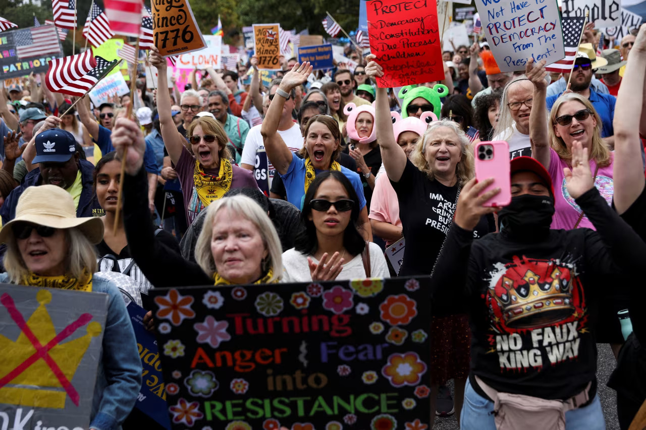 Photo of protesters with signs including: "Turning Anger and Fear into Resistance"