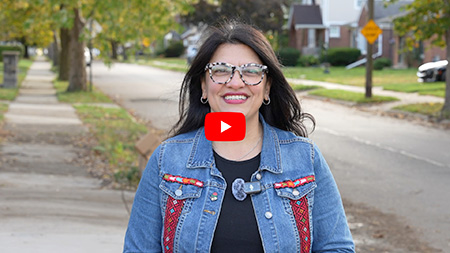 Rashida stands outside on a street, looking directly to camera Rashida stands outside on a street, looking directly to camera