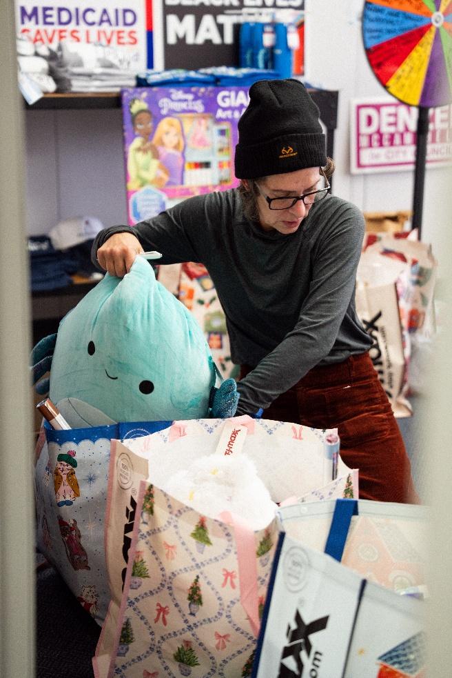A volunteer packs a squishmallow in a gift bag A volunteer packs a squishmallow in a gift bag