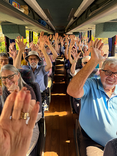 A bus full of seniors heads to Alligator Alcatraz with their hands in the air