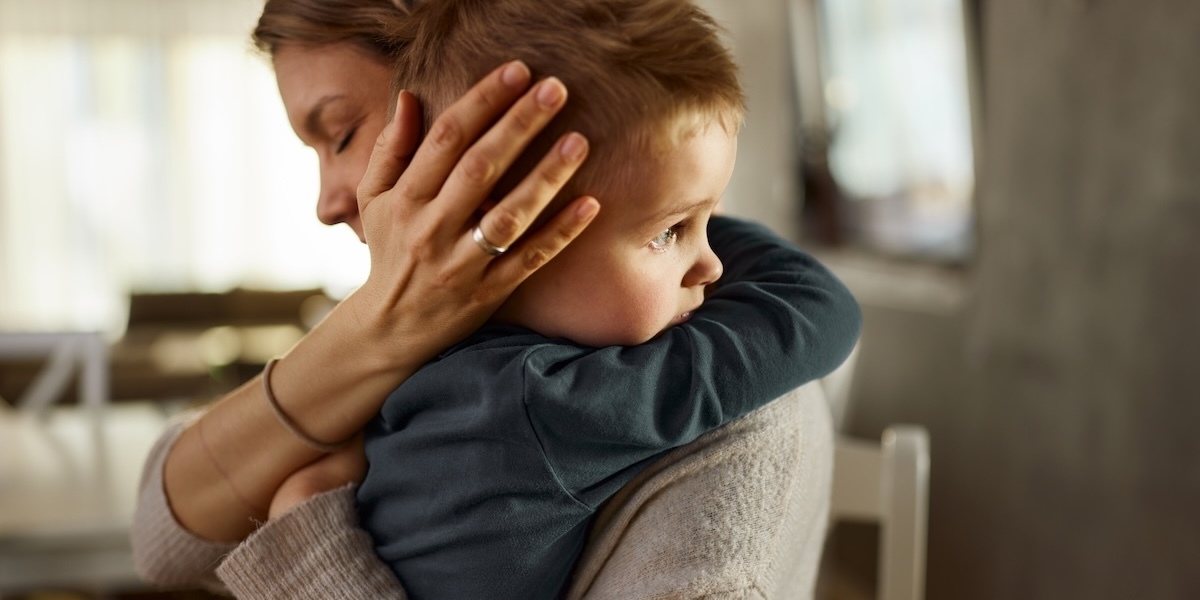 A mother embracing her child with a hug.