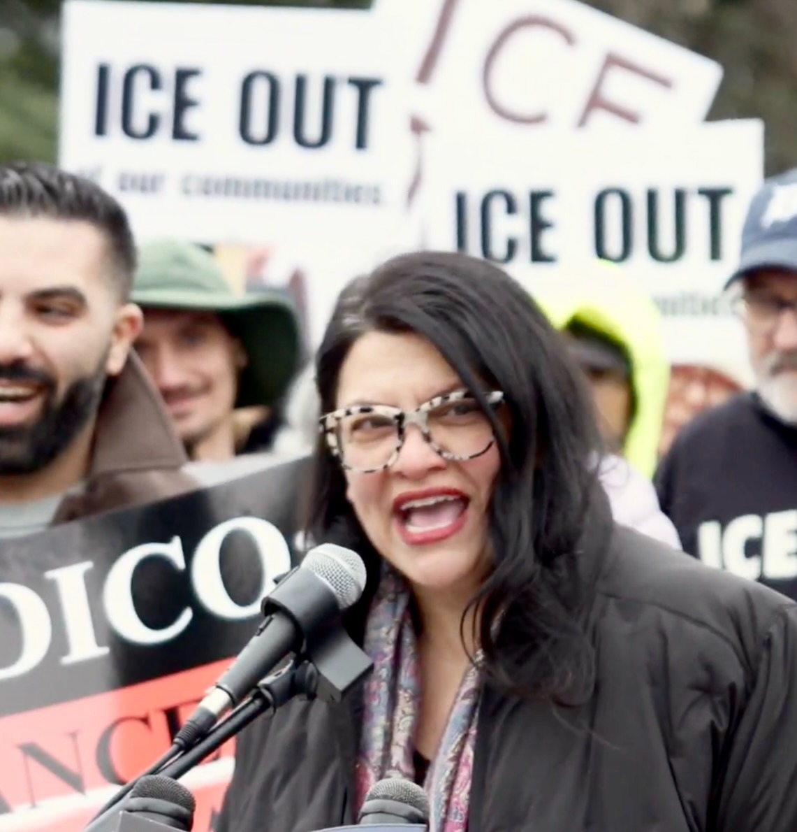 Rashida speaks into a microphone at an ICE Out rally