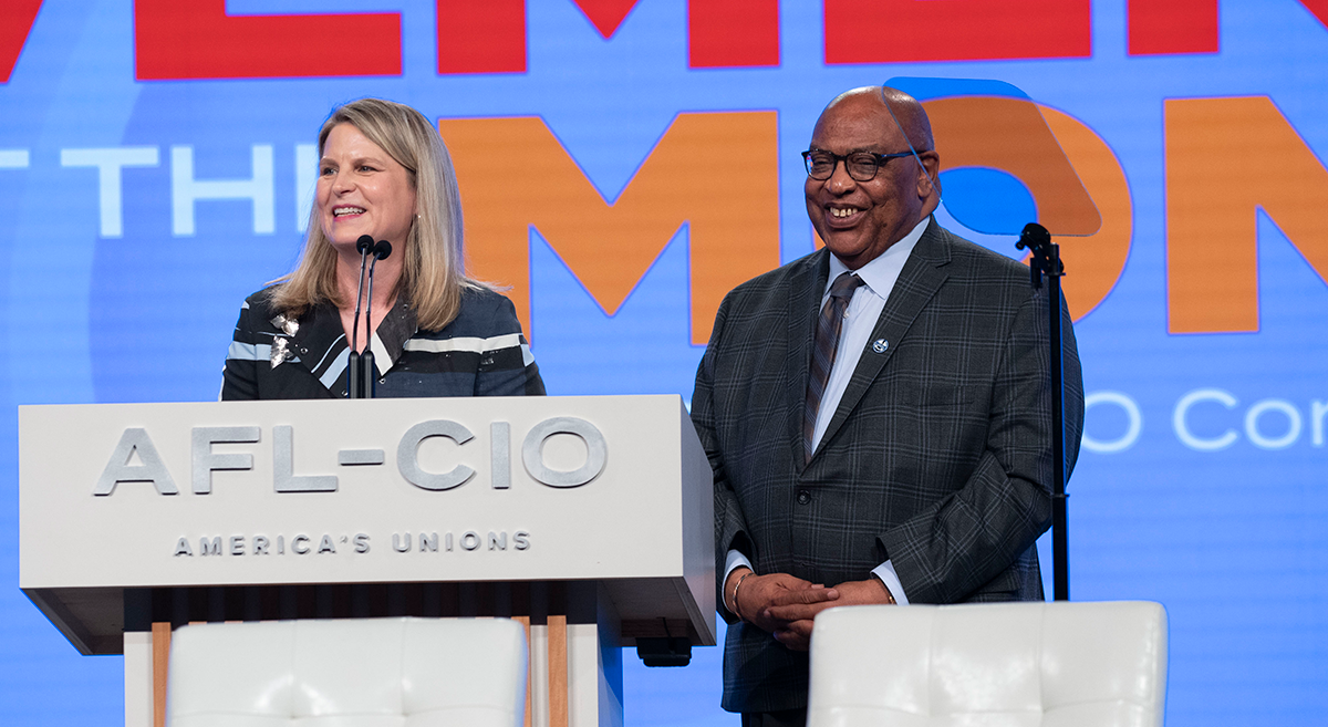 President Shuler and Secretary-Treasurer Redmond standing at a podium with the AFL-CIO logo