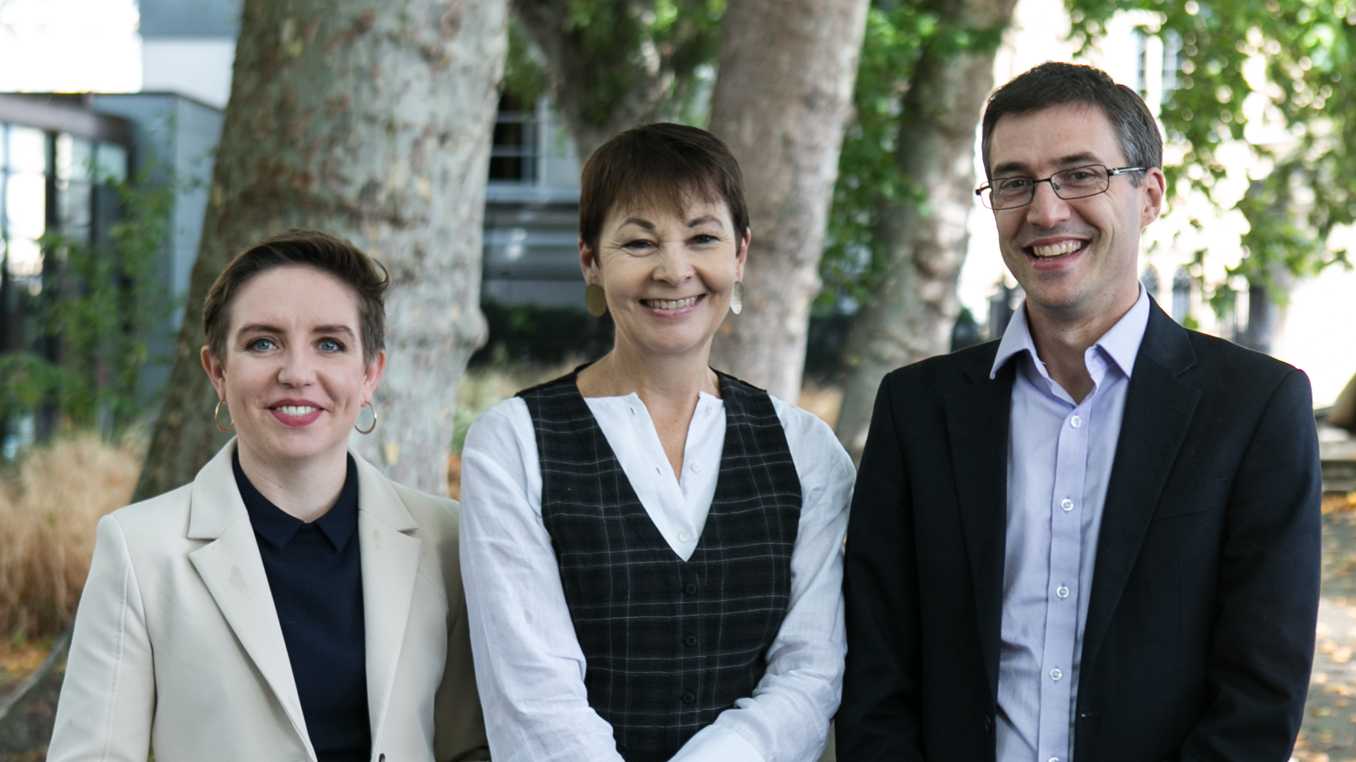 Caroline Lucas and co-leaders Carla and Adrian standing together in front of some trees